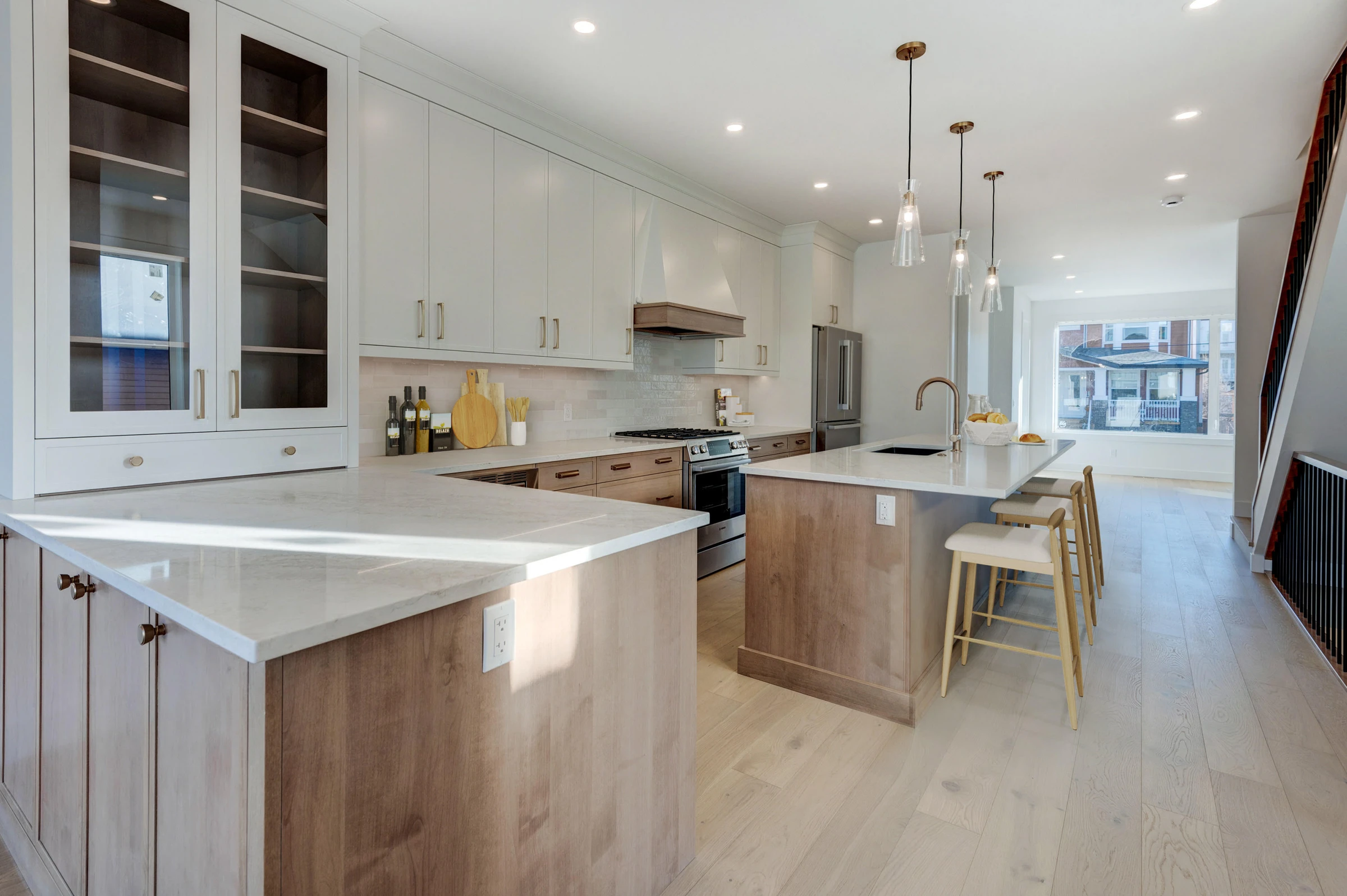 Staged galley kitchen with wood cabinetry and stainless appliances