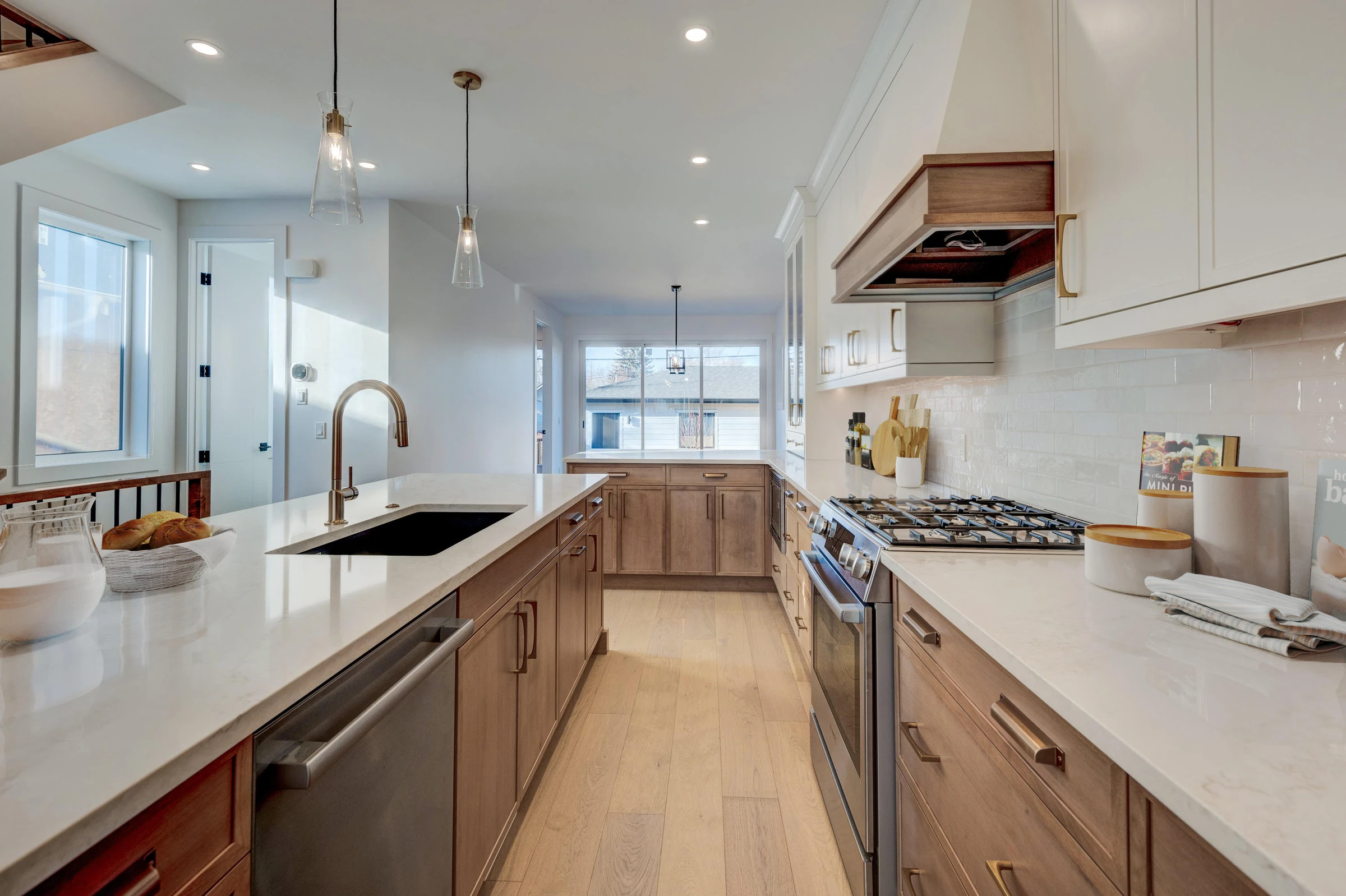 Second angle of the staged galley kitchen with subway tile and gold fixtures