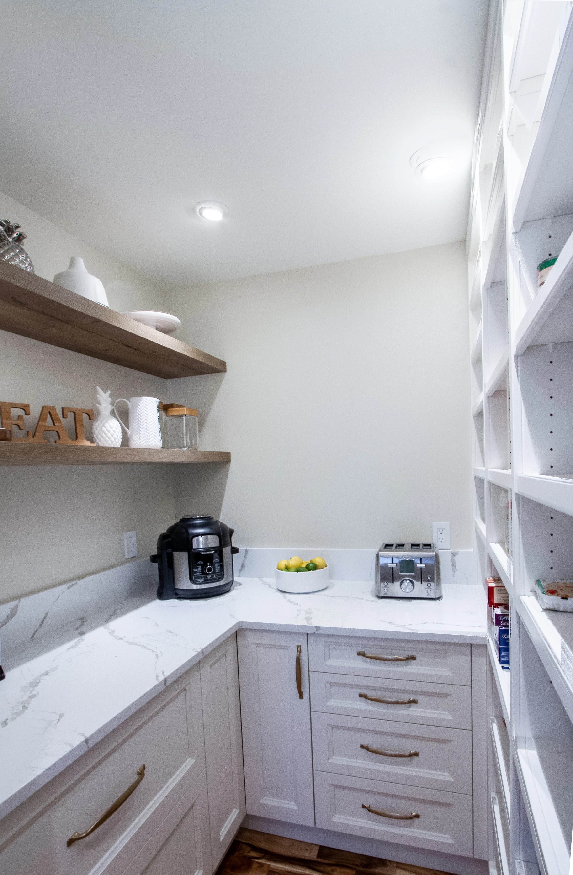 Walk-in pantry with open wood shelving and styled decor