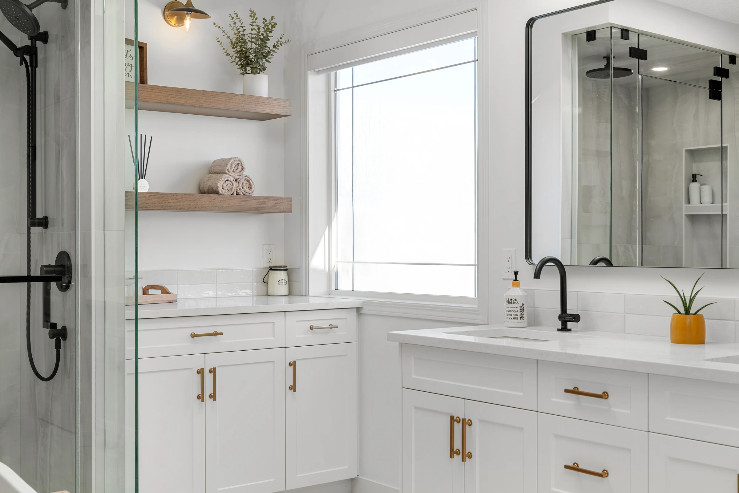Vanity detail with open wood shelving and a black-framed mirror