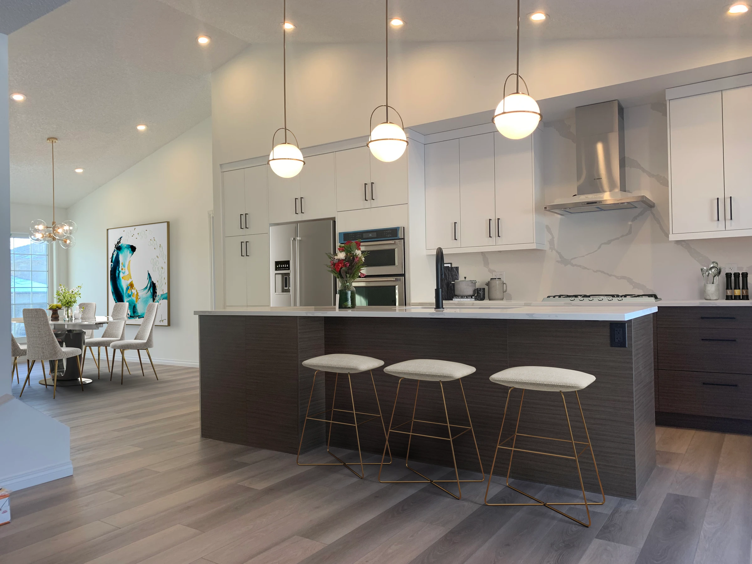 Bright vaulted-ceiling kitchen with globe pendant lighting opening to a dining nook