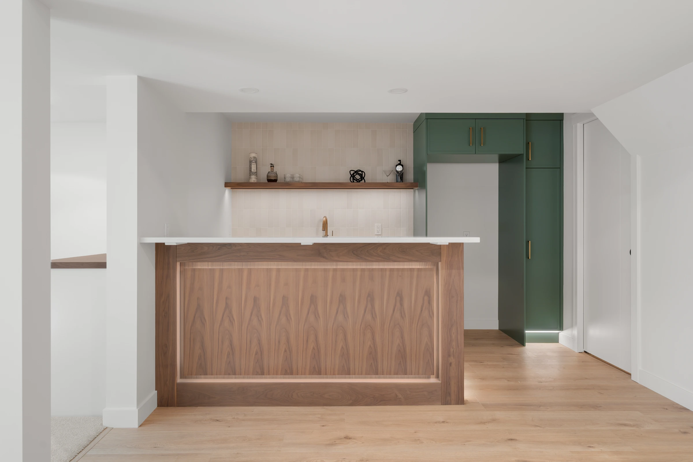 Wet bar nook with green cabinetry and a wood countertop