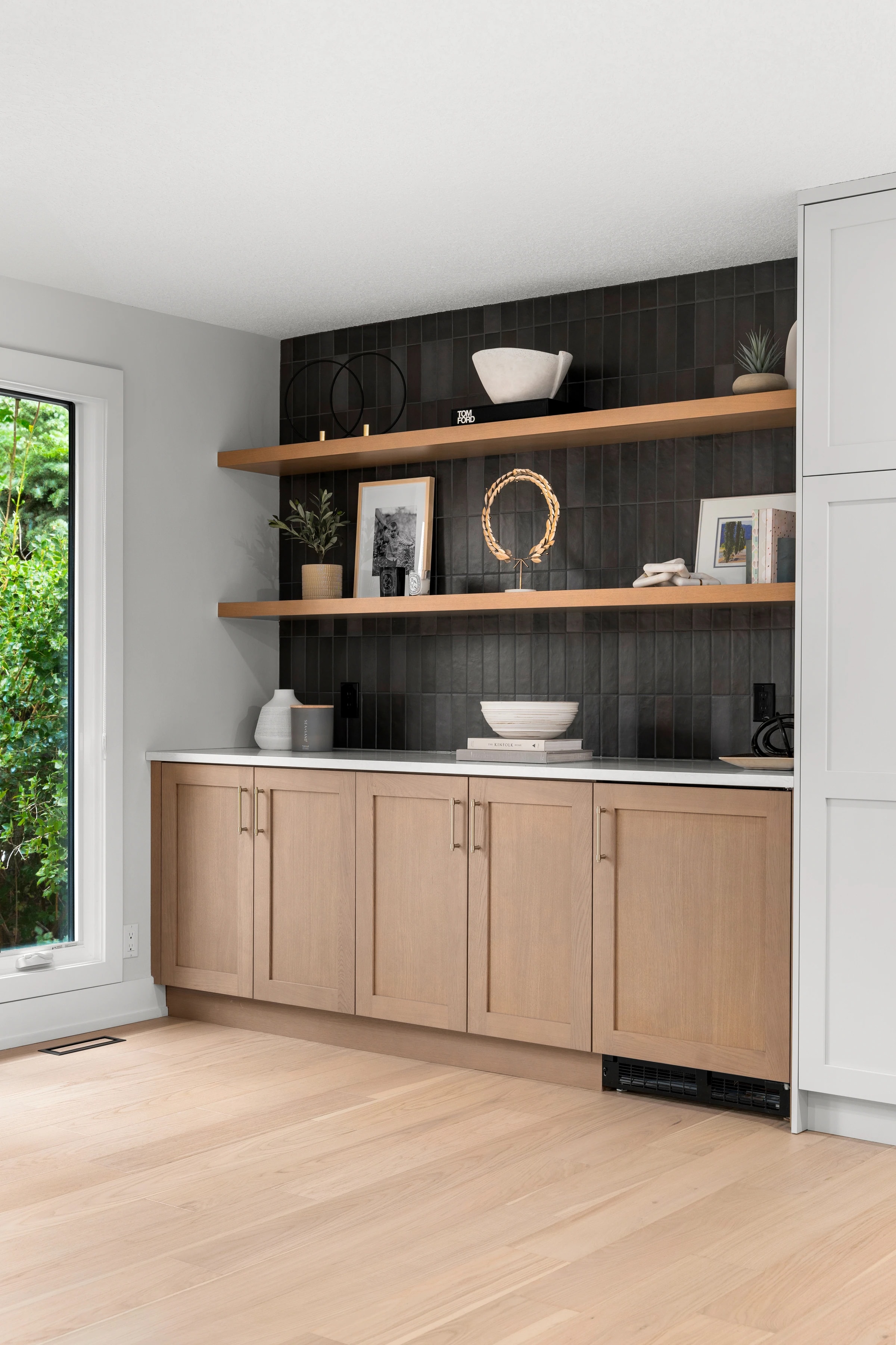 Wide view of open shelving and wood cabinetry beside a window