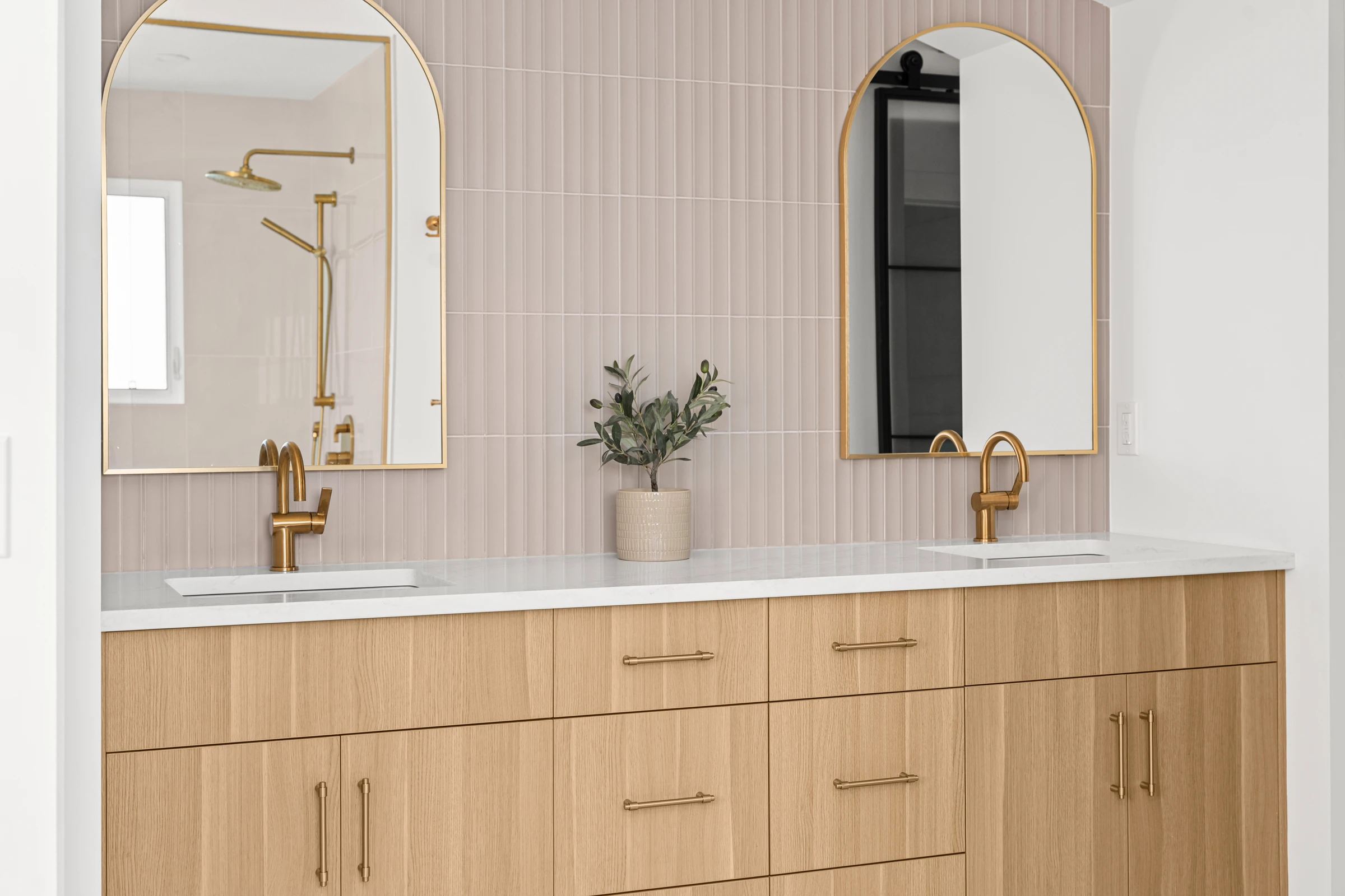 Ensuite bathroom with a walk-in shower, gold fixtures, and a pink tile accent wall