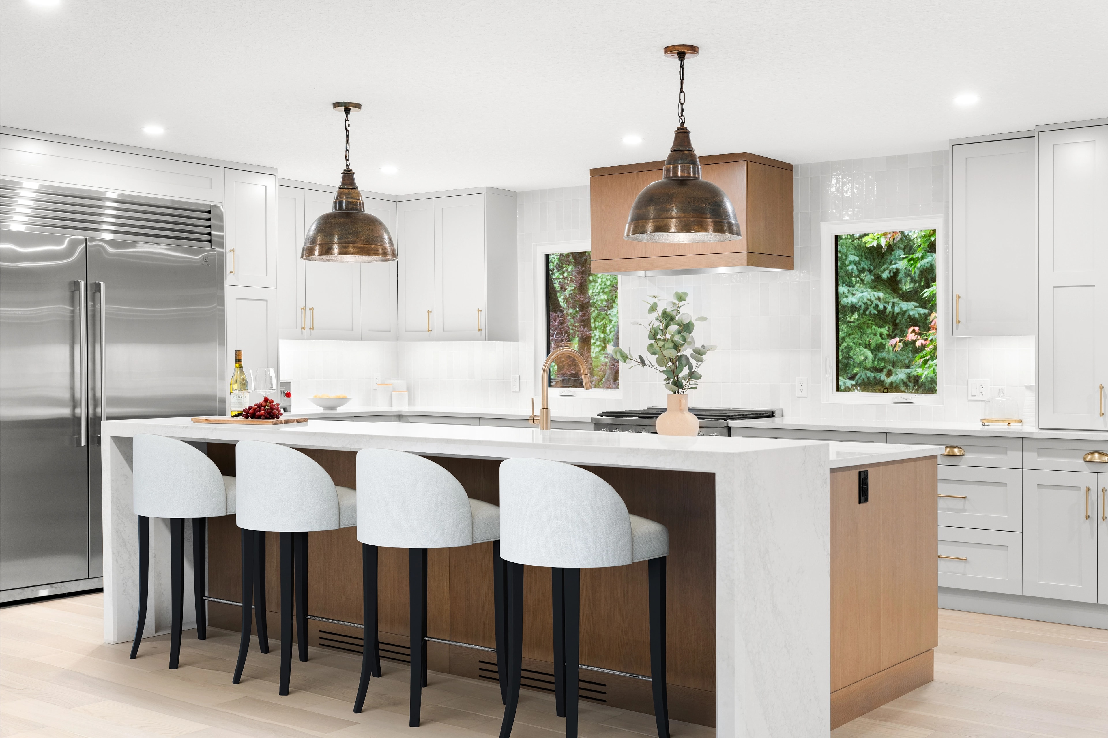 Bright kitchen with copper pendant lighting, a two-tone island, and stainless appliances