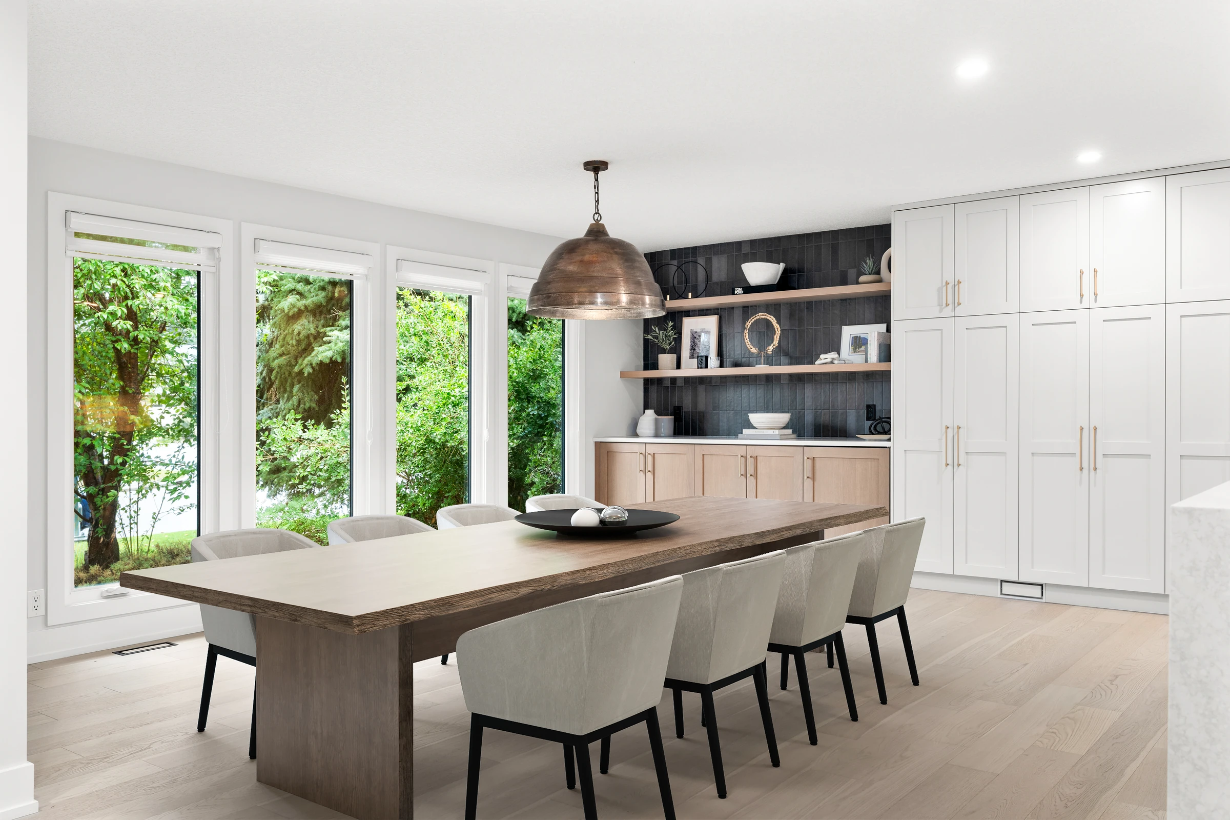 Dining area with a live-edge table, a copper pendant light, and floor-to-ceiling windows overlooking greenery