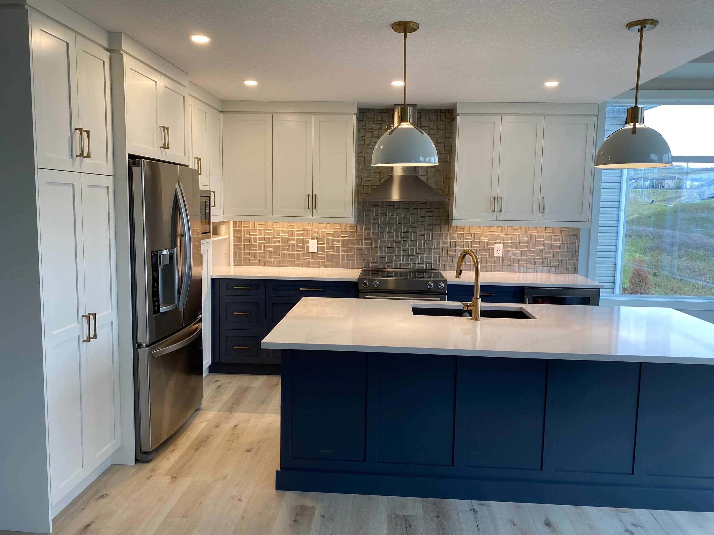 Navy blue kitchen island with white perimeter cabinets and a copper tile backsplash