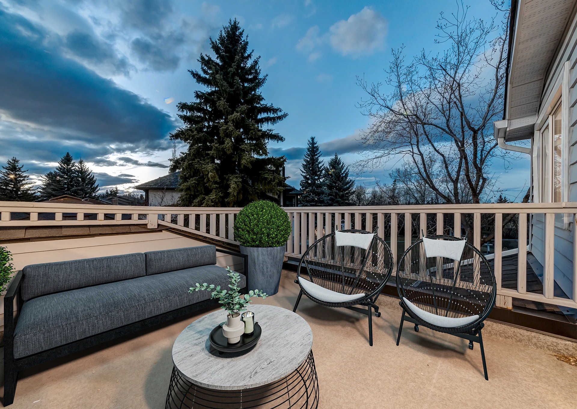 Rooftop deck with outdoor lounge seating overlooking the neighborhood at dusk