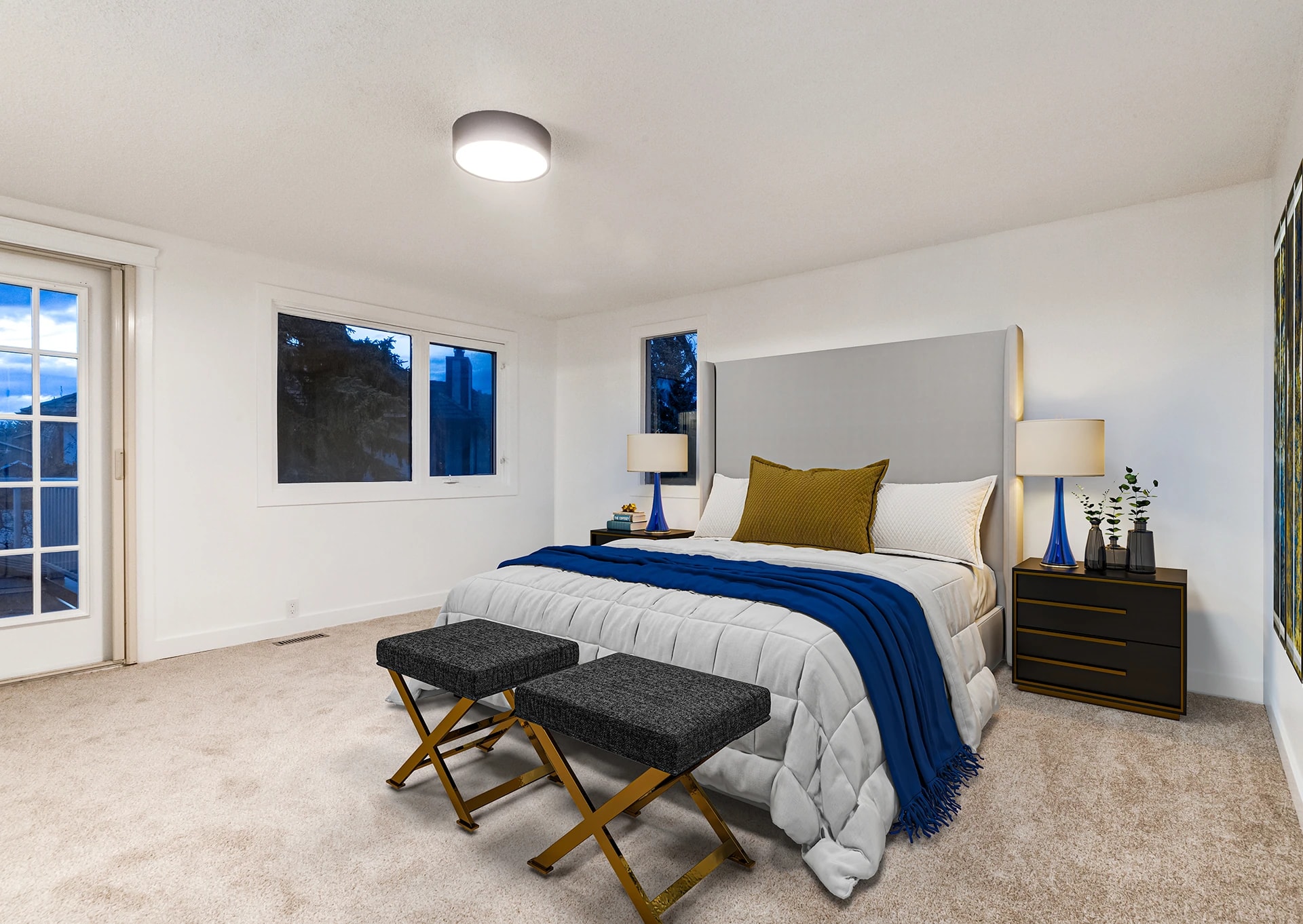 Bedroom with a tall upholstered headboard, a blue throw, and a pair of bench seats