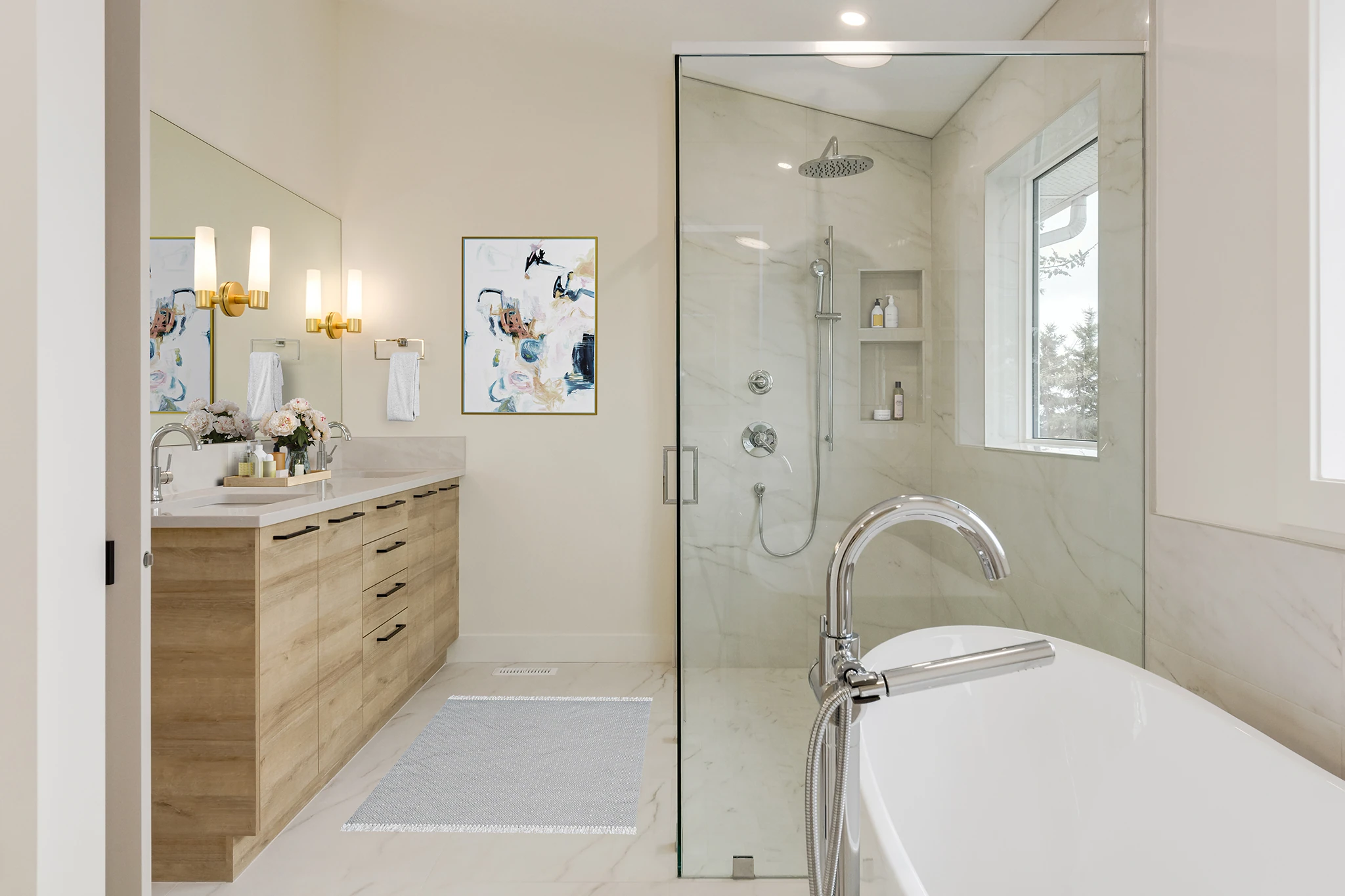 Primary bathroom with a glass shower, freestanding tub, and framed art