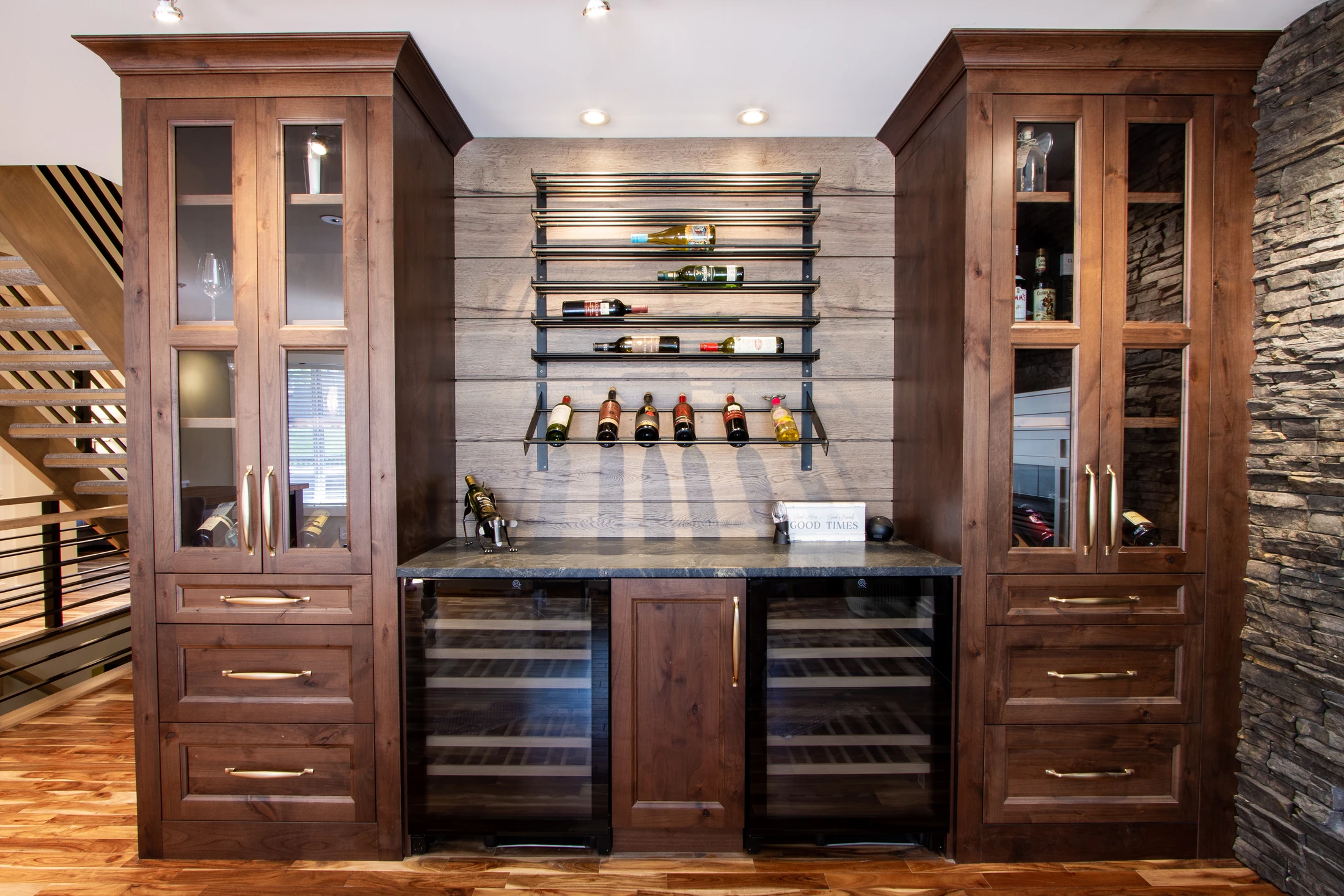 Built-in wine bar nook with dark wood cabinetry beside the staircase